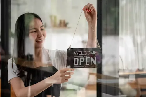 A small business owner turning the sign to open