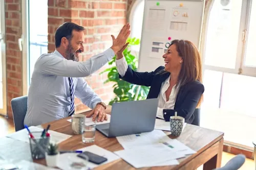 Two business partners reviewing paperwork together at a desk