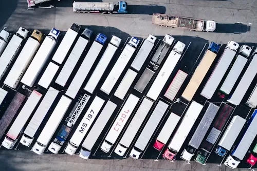 Dozens of tractor-trailers parked in rows at a freight yard